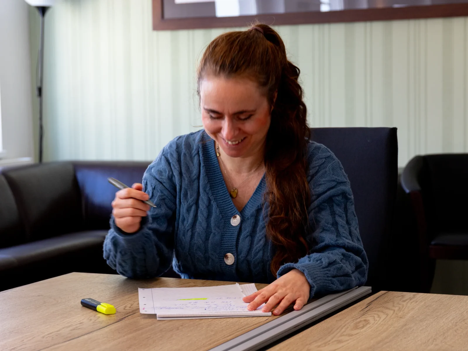 Eine Mitarbeiterin füllt Unterlagen an einem Tisch aus