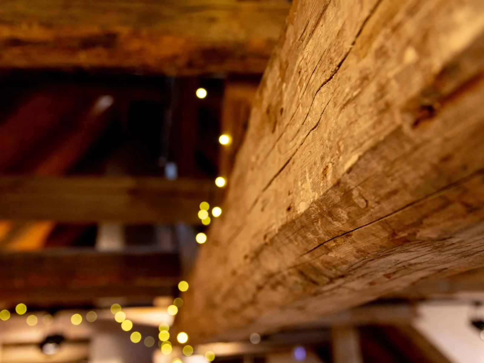 Historische Holzbalken unter der Decke des Hüfnerhauses mit Lichterkette